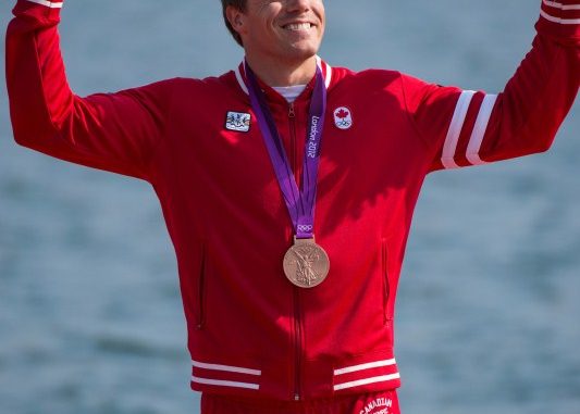 Canada's Mark de Jonge celebrates during the victory ceremony after winning a bronze medal in the K-1 200m at the 2012 London Olympic Games, August 11, 2012. The podium victory brought Canada even with its medal tally at the 2008 Beijing Games at 18. (COC Photo: Jason Ransom)